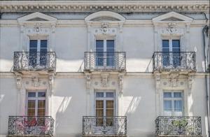 un alto edificio bianco con balconi e finestre di Les Lys D'or Appartement 3 chambres a Saumur