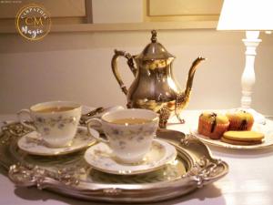 two cups of tea and a tea kettle on a table at Carpathia Magic -adults only in Peştera