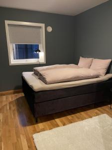 a bed sitting in a bedroom with a window at Apartment in Tromsø in Tromsø