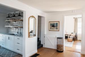 a kitchen with white cabinets and a mirror at Park and Mill - Hot Tub and Bocce Court in Bloomfield