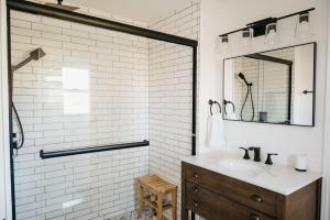 a white bathroom with a sink and a mirror at Park and Mill - Hot Tub and Bocce Court in Bloomfield +42 photos