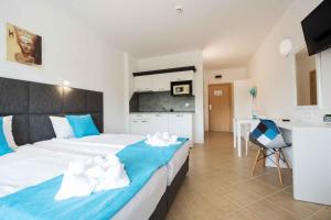 a bedroom with a large bed and a kitchen at StugioReginaNestinarka in Tsarevo