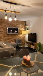 a living room with a couch and a tv at Chez jades in Saint-Julien-en-Genevois