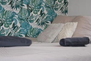 a bed with two pillows on it with a floral wall at Chez jades in Saint-Julien-en-Genevois