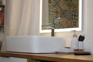 a bathroom counter with a white sink and a mirror at Chez jades in Saint-Julien-en-Genevois