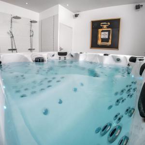 una vasca idromassaggio con acqua blu in una stanza di Les Lys D'or Appartement 3 chambres a Saumur