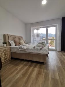 a bedroom with a large bed and a large window at Tutu Studio Sinaia cu vedere panoramica Early Checkin in Sinaia