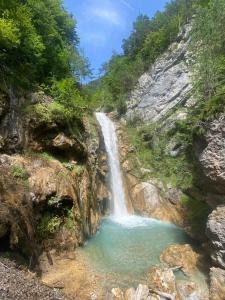 una cascata su una montagna con una piscina d'acqua di Rosenholz Ferienhäuser a Köttmannsdorf