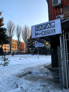 a sign for a saharanothisel on a snowy street at Safar in Karakol