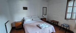 a bedroom with a bed in a white room at Residencial El Amancer in Mina Clavero