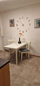 a white table with a clock on the wall at Wohnung mit Wintergarten in Rüsselsheim