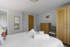 a bedroom with a large white bed with towels on it at High Hopes, Harbour Location with Sea Views in Brixham