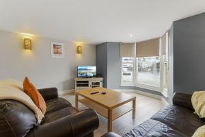 a living room with a couch and a table at High Hopes, Harbour Location with Sea Views in Brixham