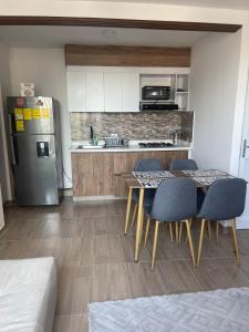 eine Küche mit Tisch und Stühlen und einem Kühlschrank in der Unterkunft Lujoso apartamento in Cartagena de Indias