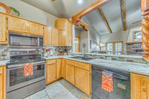 a large kitchen with wooden cabinets and stainless steel appliances at Near Hiking Trails Spacious Cloudcroft Retreat! in Cloudcroft