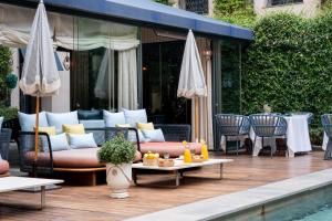 a patio with a couch and tables next to a pool at CoolRooms Palacio de Atocha in Madrid