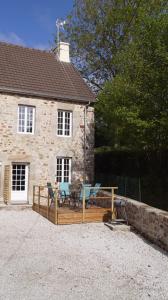 a house with a deck with chairs and a table at Le BOTELLA in Teurthéville-Hague