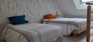two twin beds in a room with at Le BOTELLA in Teurthéville-Hague