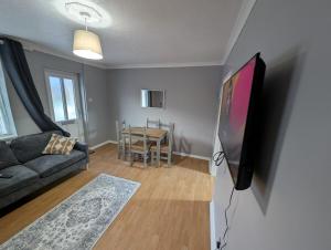 a living room with a couch and a flat screen tv at Town Centre, dedicated Parking in Burton upon Trent