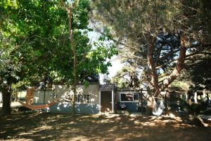 a house with a hammock in a yard with trees at Limnos Stone House in Kalliópi