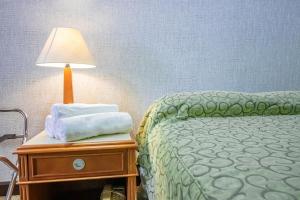 a bedroom with a bed and a lamp on a nightstand at Apto no Brasil 21 - Conforto e Localizacao Central in Brasilia