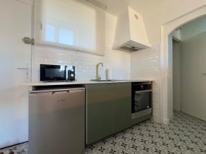 a kitchen with a sink and a microwave at Duplex - 5 min Insead - Close to Forest and Castle in Fontainebleau