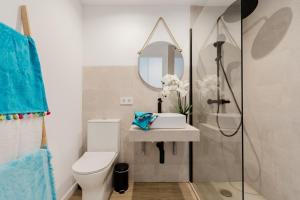 ein Badezimmer mit Toilette, Waschbecken und Spiegel in der Unterkunft Rental Holidays Apartment in Alcúdia