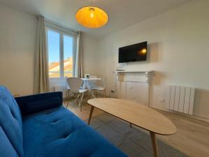 a living room with a blue couch and a table at Duplex - 5 min Insead - Close to Forest and Castle in Fontainebleau