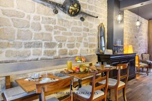 a dining room with a stone wall at Hôtel Maât Batignolles in Paris +65 photos