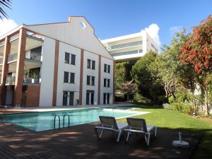 a swimming pool with two chairs in front of a building at Lagos Factory Yellow by Marina with AC in Lagos