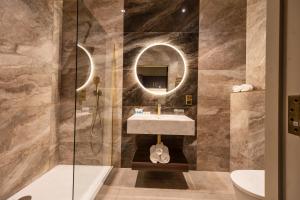a bathroom with a sink and a mirror at Walled City Hotel in Derry Londonderry