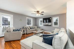 a living room with couches and a ceiling fan at Snug Harbor Sunrise Entire Home in Berlin