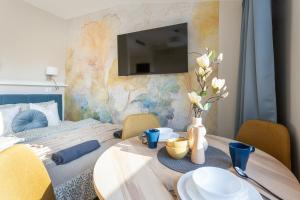 a dining room table with a tv on a wall at SuperApart Modern Stay Ursynów Pileckiego - Parking w cenie in Warsaw