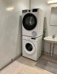 a washing machine and a sink in a bathroom at Koselig soveplass i sentrum av Narvik Gratis Wifi og Parkering Rom 2 in Narvik