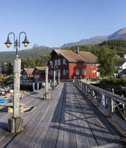 a wooden boardwalk with a red building and a dock at Koselig soveplass i sentrum av Narvik Gratis Wifi og Parkering Rom 2 in Narvik