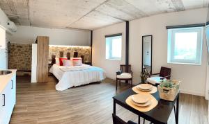 a bedroom with a bed and a table with chairs at Láurea Ecocasona in Oreña