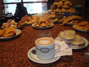a table with a cup of coffee and plates of pastries at Italia in Buenos Aires