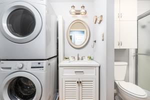 a bathroom with a washing machine and a sink at Snug Harbor Sunrise Entire Home in Berlin +64 photos