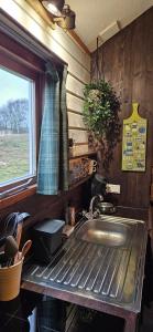 une cuisine avec un évier et une fenêtre dans l'établissement The Kottage, à Oostkapelle