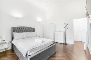 een witte slaapkamer met een bed en een ladekast bij Security House in Londen