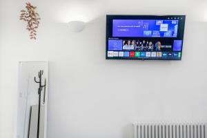 een flatscreen-tv aan de muur naast een radiator bij Security House in Londen