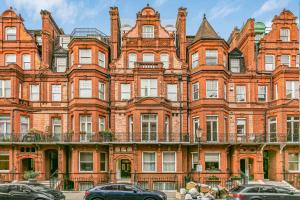 een groot gebouw van rode baksteen met auto's voor de deur bij Security House in Londen