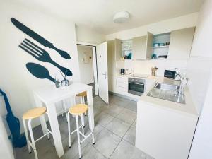 una cucina con bancone, sgabelli e lavandino di The5Continents III - Youth Hostel by Stay Swiss a Porrentruy