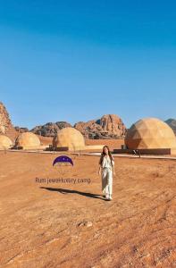 Eine Frau, die in einer Wüste mit Kuppeln im Hintergrund wandelt. in der Unterkunft Buble camp tour in Disah + 7 Fotos