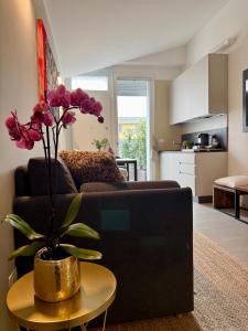 a living room with a couch and a table with a plant at Mood's Home BLQ in Bologna