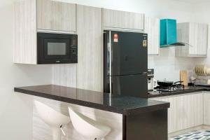 a kitchen with a black refrigerator and a microwave at Taiping Peaceful Retreat near Lake Garden with WiFi in Taiping