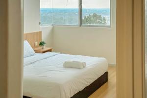 a bedroom with a large white bed in front of a window at Taiping Peaceful Retreat near Lake Garden with WiFi in Taiping +40 photos