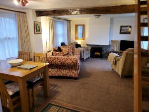 ein Wohnzimmer mit Couch und Kamin in der Unterkunft Holly Cottage Grasmere in Grasmere