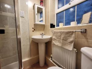 ein Badezimmer mit Waschbecken, Toilette und Dusche in der Unterkunft Holly Cottage Grasmere in Grasmere + 23 Fotos