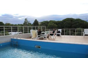 two people sitting in chairs on a deck by the water at Nómade Hostel mdz in Mendoza +42 photos